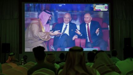 Diplomate. La Russie vient d'ouvrir le score, alors pour éviter tout incident diplomatique, le président russe Vladimir Poutine dit qu'il n'y peut pas grand chose au prince héritier d'Arabie saoudite, Mohammed ben Salmaneb... Entre les deux hommes, le président de la Fifa Gianni Infantino savoure cette scène. (FAYEZ NURELDINE / AFP)