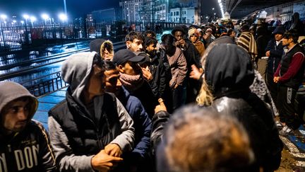 Des migrants attendent lors d'une distribution alimentaire sous le pont du métro entre les stations La Chapelle et Barbès, le 15 novembre 2022. (MICHAEL BUNEL / MAXPPP)