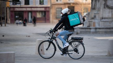 Un livreur à vélo dans les rues d'Aix-en-Provence (Bouches-du-Rhône), en mars 2020. (CLEMENT MAHOUDEAU / AFP)