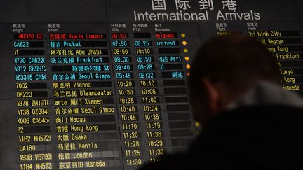 Le tableau d'affichage &agrave; l'a&eacute;roport de P&eacute;kin (Chine), o&ugrave; devait atterir, le 8 mars 2013, un vol de la Malaysia Airlines port&eacute; disparu.&nbsp; (MARK RALSTON / AFP)