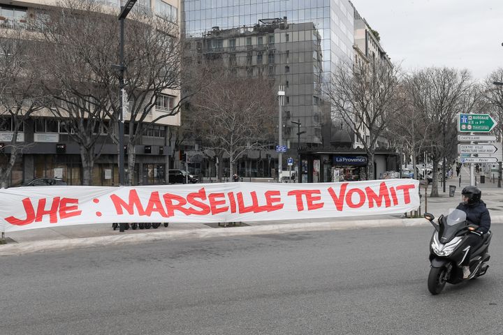 Un conducteur observe une bannière déployée par des supporters de l'OM visant le président du club Jacques-Henry Eyraud, à Marseille, le 30 janvier 2021. (NICOLAS TUCAT / AFP)