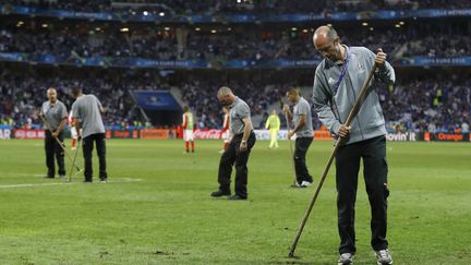 Les jardiniers tentent de reboucher les trous sur la pelouse du stade Pierre-Mauroy de Lille, dimanche 19 juin 2016. (REUTERS)