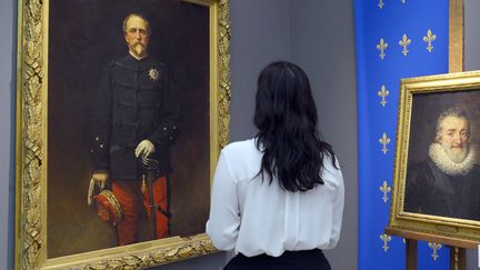 Une femme devant deux tableaux d'Henri Orléans aux enchères chez Sotheby's.
 (Bertrand Guay / AFP)