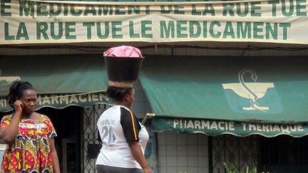 Un slogan accroché à la facade d'une pharmacie de Yaoundé rappelle l'importance et le danger des médicaments de l'économie grise. (Reinnier KAZE / AFP)