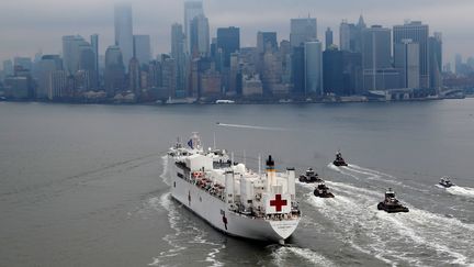 Le navire-hôpital militaire USNS Comfort approche de la baie de New York (Etats-Unis), le 30 mars 2020, afin d'apporter une logistique et de soulager les&nbsp;établissements de santé de la ville. (MIKE SEGAR / REUTERS)