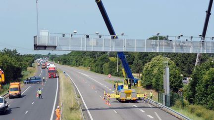 Un portique &eacute;cotaxe est d&eacute;mont&eacute;, le 23 juin 2014, pr&egrave;s de Prinquiau (Loire-Atlantique). (THOMAS BREGARDIS / AFP)