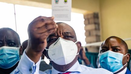 Le vice-président et ministre de la Santé du Zimbabwe, Constantino Chiwenga, brandit son certificat de vaccination après avoir reçu la première injection de&nbsp;Sinopharm, le vaccin chinois contre le Covid-19, le 18 février 2021. (JEKESAI NJIKIZANA / AFP)