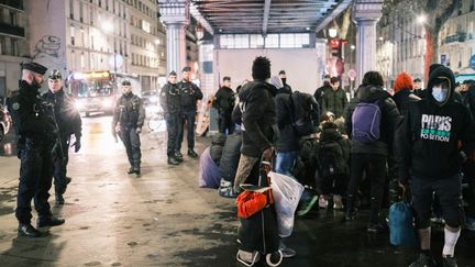 Les forces de l'ordre contrôlent des exilés installés sous le métro aérien, à Paris, le 28 décembre 2022. (ANNA MARGUERITAT / HANS LUCAS / AFP)