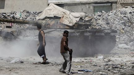 Les rebelles syriens prennent possession d'un char de l'arm&eacute;e syrienne, dans le nord d'Alep, le 4 ao&ucirc;t 2012. (AHMAD GHARABLI / AFP)