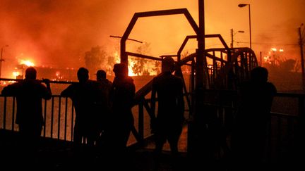 La station balnéaire de Vina del Mar, dans une région où des températures caniculaires sévissent, est particulièrement touchée. Sur cette image, des habitants observent les flammes détruire des habitations dans la ville, le 2 février 2024. (CRISTOBAL BASAURE / AP / SIPA)