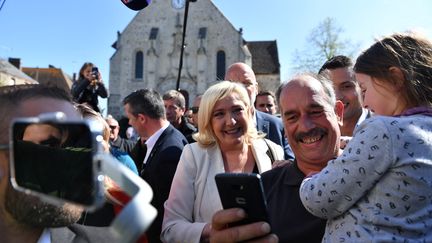 La candidate Marine Le Pen prend un selfie avec un habitant pendant son déplacement à&nbsp;Saint-Rémy-sur-Avre, en Eur-et-Loire. (JULIEN DE ROSA / AFP)