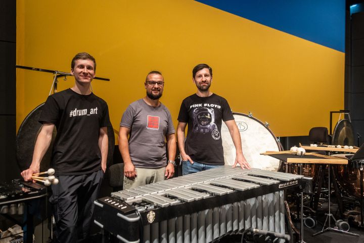 Yehven Ulianov, Dmytro Ilin and Sviatoslav Yanchuk, Ukrainian musicians and members of the Ukrainian Freedom Orchestra pose for a photo after a rehearsal by the Ukrainian Freedom Orchestra at the Warsaw Opera before their international tour, July 28, 2022 (WOJTEK RADWANSKI / AFP)