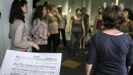 FRANCE, Lyon : POUR ILLUSTRER LE PAPIER : &quot;TENDANCE - CHANTER DANS SON ENTREPRISE, NOUVEAU REMEDE AU MAL-ETRE AU TRAVAIL&quot; : Des employés d&#039;Orange répètent au sein de la chorale de l&#039;entreprise, le 8 juin 2012 à Lyon. Les chorales d&#039;entreprises se multiplient partout en France, à l&#039;initiative de salariés voire, comme chez Orange, de directions, qui y voient un nouveau moyen de remédier au mal-être au travail. AFP PHOTO / JEAN-PHILIPPE KSIAZEK
 (AFP PHOTO / JEAN-PHILIPPE KSIAZEK)