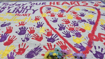 Un mémorial réunit les empreintes&nbsp;des passants sous les mots "Nos coeurs crient&nbsp;à l'unisson", près du club Pulse à Orlando, le 12 juin 2016. (MANDEL NGAN / AFP)