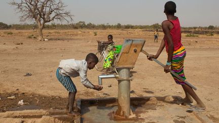 Des enfants près d'un puits dans un village au Burkina Faso (Antoine BOUREAU / AFP)