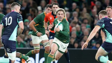 Le demi de mêlée sud-africain Faf de Klerk prend l'intervalle dans la défense irlandaise, devant Johnny Sexton, lors du match Irlande-Afrique du Sud, le 5 novembre 2022 à Dublin (Irlande). (PAUL FAITH / AFP)