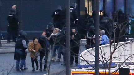 Des hommes de l'unit&eacute; d'&eacute;lite de la police &eacute;vacuent les otages apr&egrave;s avoir lanc&eacute; l'assaut sur le supermarch&eacute; casher attaqu&eacute;, le 9 janvier 2015 &agrave; Paris. (THOMAS SAMSON / AFP)