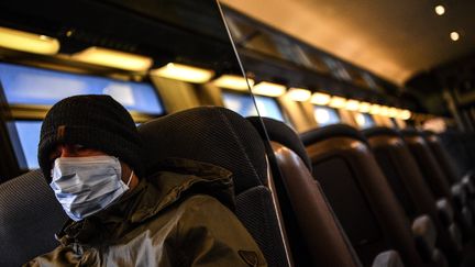 Un homme portant un masque dans un train à Paris, le 17 mars 2020. (CHRISTOPHE ARCHAMBAULT / AFP)