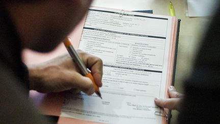 Un jeune homme signe un contrat de travail, &agrave; Beauvais (Oise), le 17 mai 2013. (FRED DUFOUR / AFP)