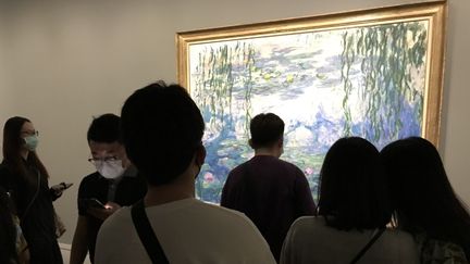 Des visiteurs de l'exposition à Shanghai devant un tableau de la série des "Nymphéas" de Claude Monet, juillet 2021 (DOMINIQUE ANDRE / RADIO FRANCE)