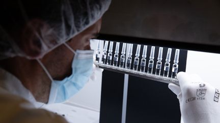 Un technicien de laboratoire inspecte des seringues au centre de distribution mondial du groupe pharmaceutique français Sanofi à Val-de-Reuil dans l'Eure, le 10 juillet 2020 (photo d'illustration). (JOEL SAGET / AFP)