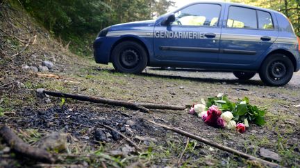 Un bouquet de rose déposé&nbsp;sur une route forestière où quatre personnes ont été tuées&nbsp;&nbsp;le 5&nbsp;septembre&nbsp;2012 à Chevaline en Haute-Savoie. (PHILIPPE DESMAZES / AFP)