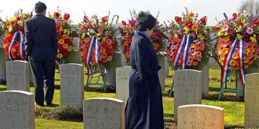 Deux personnes parcourent les tombes du cimetière chinois de Noyelles-sur-Mer à l'occasion de l'hommage rendu aux ouvriers du Chinese Labour Corps par des représentants de la diaspora chinoise le 5 avril 2003. (AFP - Philippe Huguen)