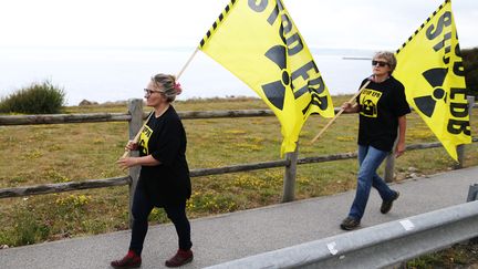 Des activistes de Greenpeace marchant contre le nucléaire devant le site de Flamanville, le 28 juin 2018. (CHARLY TRIBALLEAU / AFP)