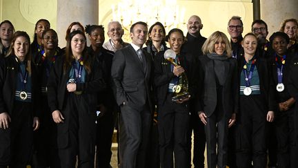 Les handballeuses françaises sur le perron de l'Elysée en compagnie de Brigitte et Emmanuel Macron, lundi 18 décembre 2023 à Paris. (JULIEN DE ROSA / AFP)