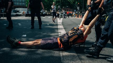 Un militant est tiré par les forces de l'ordre afin de dégager&nbsp;le pont de Sully à Paris par les&nbsp;militants du collectif&nbsp;Extension Rebellion, le 28 juin 2019. (MATHIAS ZWICK / HANS LUCAS)