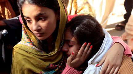 Deux femmes pleurent la mort d'un de leurs proches, victime d'une liqueur toxique, le 27 décembre 2016, à Toba Tek Singh (Pakistan). (FAYYAZ HUSSAIN / REUTERS)