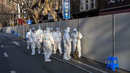 Des agents sanitaires équipés de vêtements de protection dans une zone confinée de Shanghai après la détection de nouveaux cas de Covid-19, le 15 mars 2022.&nbsp; (HECTOR RETAMAL / AFP)