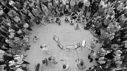 Des personnes écoutent un concert, à Paris, lors de la fête de la musique, le 21 juin 1982. (JOEL ROBINE / AFP)