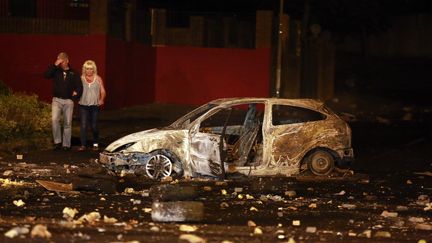 Une voiture incendi&eacute;e dans des affrontements entre manifestants et forces de l'ordre, le 16 juillet 2013 &agrave; Belfast (Irlande du Nord).&nbsp; (CATHAL MCNAUGHTON / REUTERS)