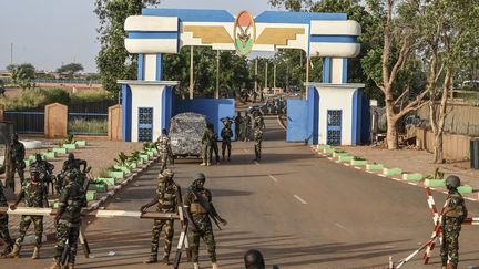 Des soldats montent la garde alors que des partisans de la junte militaire au pouvoir au Niger manifestent devant une base aérienne pour exiger le départ de l'armée française, à Niamey, le 16 septembre 2023. (AFP)