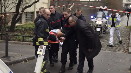 Un bless&eacute; est &eacute;vacu&eacute; des locaux de "Charlie Hebdo" par les secours, le 7 janvier 2015, &agrave; Paris. (MARTIN BUREAU / AFP)