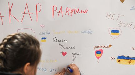 Des enfants ukrainiens réfugiés en France dessinent sur un mur dans un centre d'accueil à Paris, en mars 2022. Photo d'illustration. (ALAIN JOCARD / AFP)