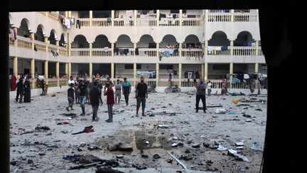 Palestinians look at the damage from airstrikes that hit al-Tabi'een school in Gaza City on August 10, 2024. (OMAR AL-QATTAA / AFP)