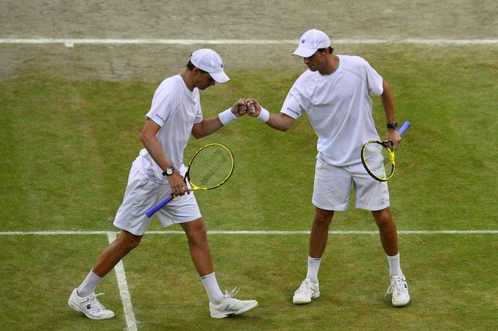 Les tennismen am&eacute;ricains Bob et Mike Bryan effectuent un "fist bump" lors d'un match, le 5 juillet 2014, &agrave; Wimbledon (Royaume-Uni). (CARL COURT / AFP)