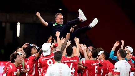 Hans-Dieter "Hansi" Flick porté en triomphe par ses joueurs après la victoire en Coupe d'Allemagne (ROBERT MICHAEL / POOL)