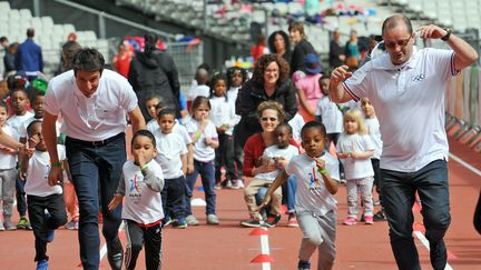 Tony Estanguet, le président du comité olympique français et Patrick Baumann, le président du comité d'évaluation du CIO, pendant une course avec des écoliers, le 15 Mai 2017, au Stade de France à Saint-Denis.&nbsp; (GETTY IMAGES)