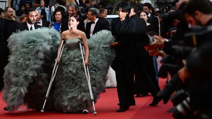 C'est une arrivée... remarquée. L'actrice cambodgienne Shin Yubin est arrivée en béquilles sur le tapis rouge, à l'occasion de la projection de "Monster". Rassurez-vous, même blessée, elle a réussi à monter les 24 marches du Palais des Festivals. (CHRISTOPHE SIMON / AFP)