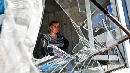 Une femme apparaît dans l'encadrement de la fenêtre de sa maison détruite par un tir de roquette russe, à Zaporizhzhia (Ukraine), en septembre 2022. (DMYTRO SMOLIENKO / AVALON / MAXPPP)