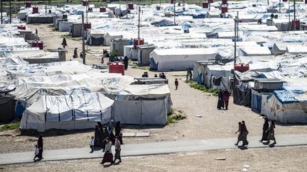 Des femmes et des enfants marchent à l'intérieur du camp Roj, où sont détenus des proches de personnes soupçonnées d'appartenir au groupe État islamique, le 28 mars 2021. (DELIL SOULEIMAN / AFP)