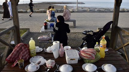 Rompre le jeûne à la plage est courant en Tunisie et le phénomène se développe au Maroc, à la faveur d'un mois de ramadan tombé l'été ces dernières années - il est basé sur le calendrier lunaire. Le phénomène est quasi inexistant sur la côte algérienne, à l'exception d'Annaba, près de la frontière tunisienne, et il est très récent à Alger. Il y est apparu timidement durant le ramadan 2015 avec la fin de travaux d'assainissement et d'aménagement d'une promenade agrémentée de kiosques, balançoires et manèges aux Sablettes. La rénovation de cette plage, longtemps polluée et difficile à atteindre, a rendu un accès à la mer aux riverains, qui en étaient depuis longtemps privés par une autoroute et par des installations portuaires occupant une large partie de la baie d'Alger.
 (RYAD KRAMDI / AFP)