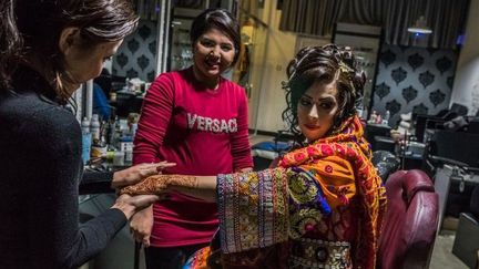 Une jeune afghane vêtue d'une robe de mariage traditionnelle dans un salon de beauté à Kaboul.   (Rebecca Conway / AFP)