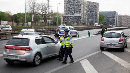 Des policiers procèdent à un contrôle d'autorisation de circuler le 11 avril 2020, à Paris. (THOMAS SAMSON / AFP)