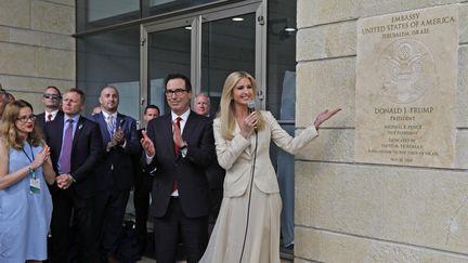 Le secrétaire d'Etat au Trésor américain Steve Mnuchin et Ivanka Trump, fille et conseillère du président des Etats-Unis,&nbsp;posent devant la plaque de la nouvelle ambassade américaine à Jérusalem,le 14 mai 2018. (MENAHEM KAHANA / AFP)