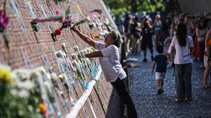 Des fleurs sont déposées sur un mur à Ban Nam Khem, un mémorial dédié à la mémoire des victimes thaïlandaises de la catastrophe, dans la province de Phang Nga, dans le sud du pays. (LILLIAN SUWANRUMPHA / AFP)