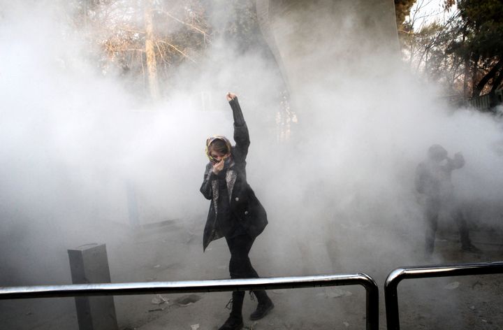 Une femme iranienne au milieu des gaz lacrymogènes devant l'Université de Téhéran lors d'une manifestation le 30 décembre 2017&nbsp; (STR / AFP)